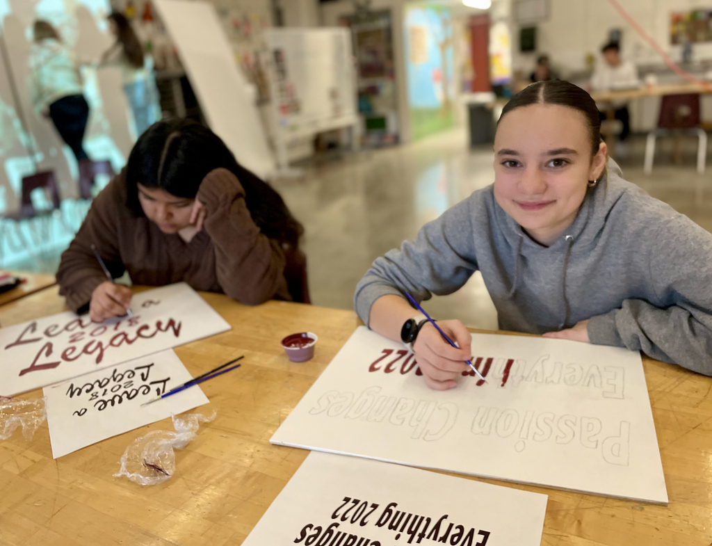 female students working on the lettering for murals