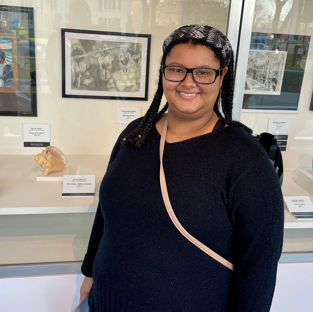 female student next to her ceramic seashell, "The voice of Many Oceans"
