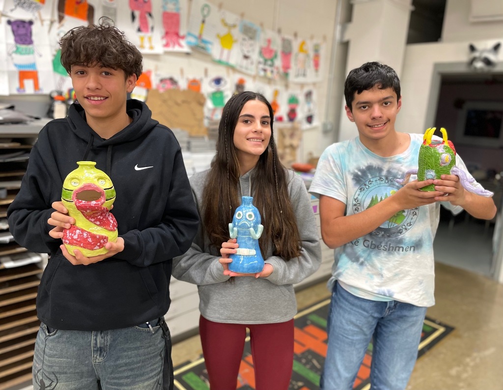 students holding their monster projects 