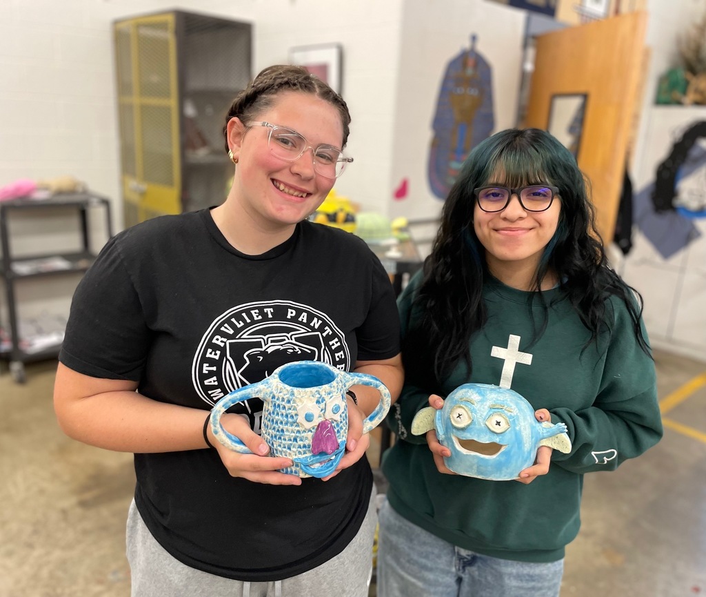 girls holding their monster projects