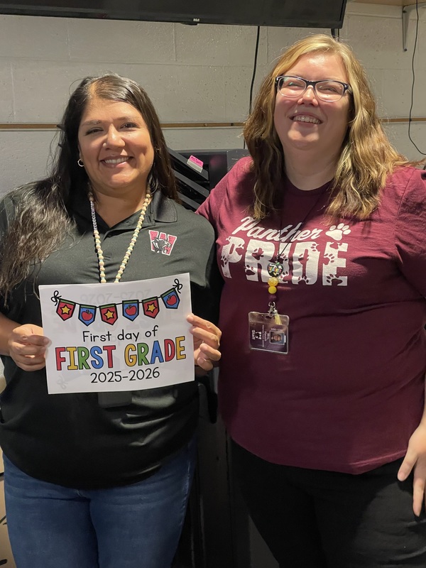 two teachers, one holding sign