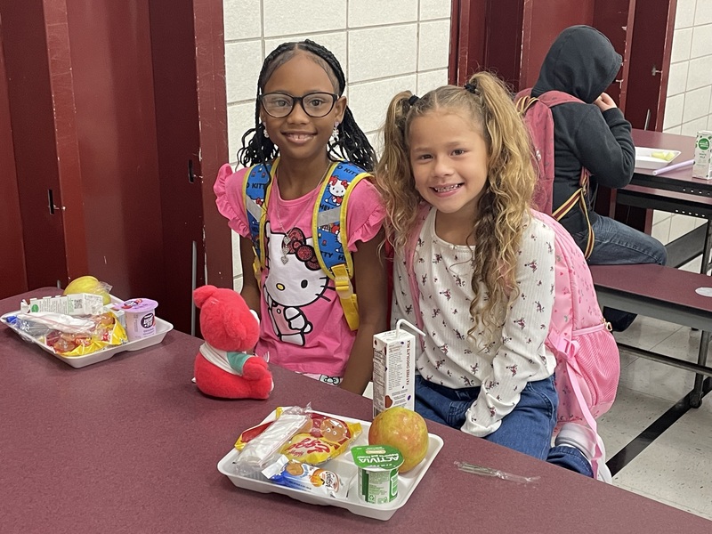 two little girls with lunch trays