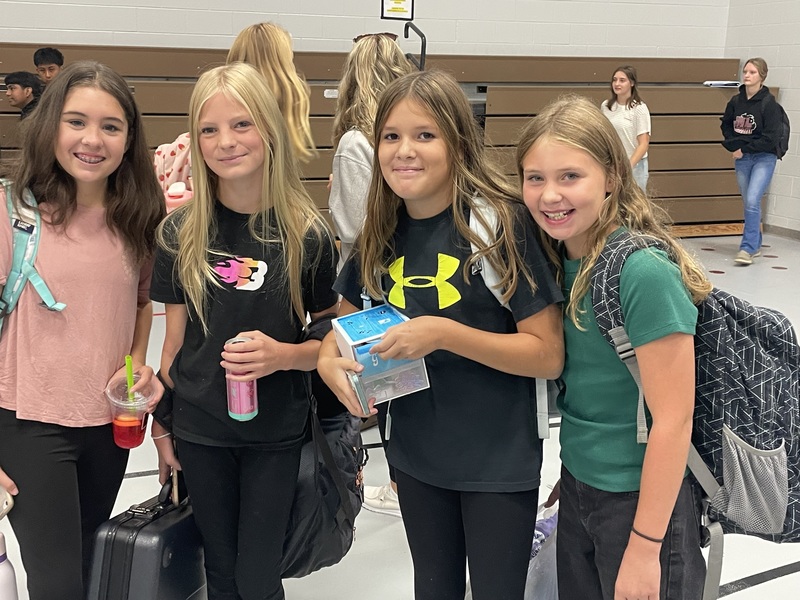 four middle school age girls smile for the camera