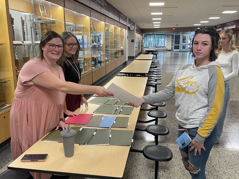 guidance office staff handing out schedules to students