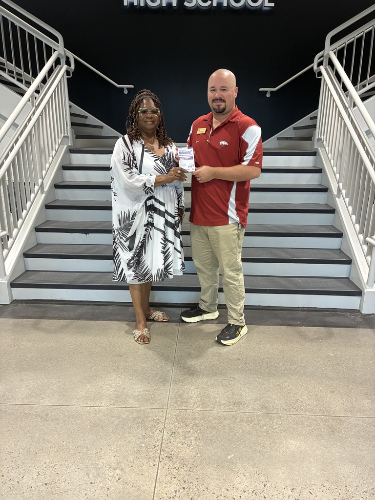 a man and woman standing in front of stairs holding a box