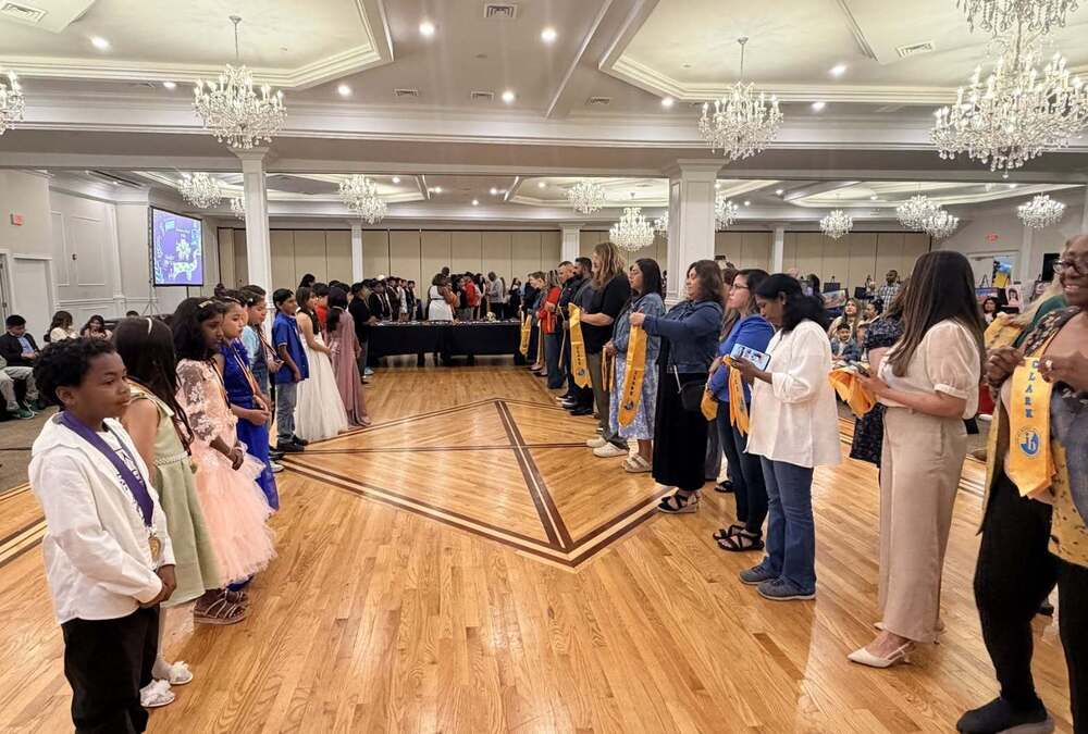 5th Grade Parents line up to place a stole around their children 