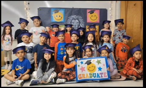 Kindergarten students group picture waring graduation gowns