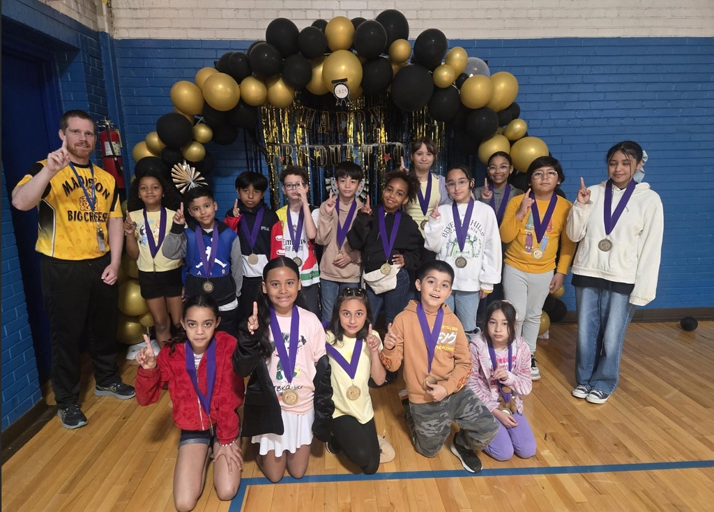 Students wearing award medals posing with their gym teacher