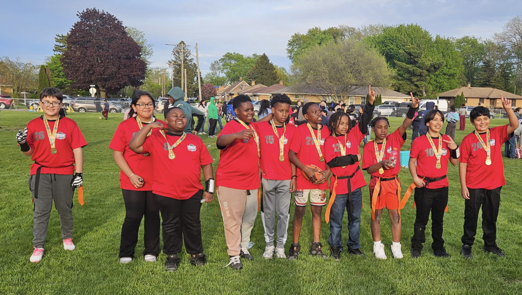 A group photo of the school's flag football team proudly wearing their championship medals