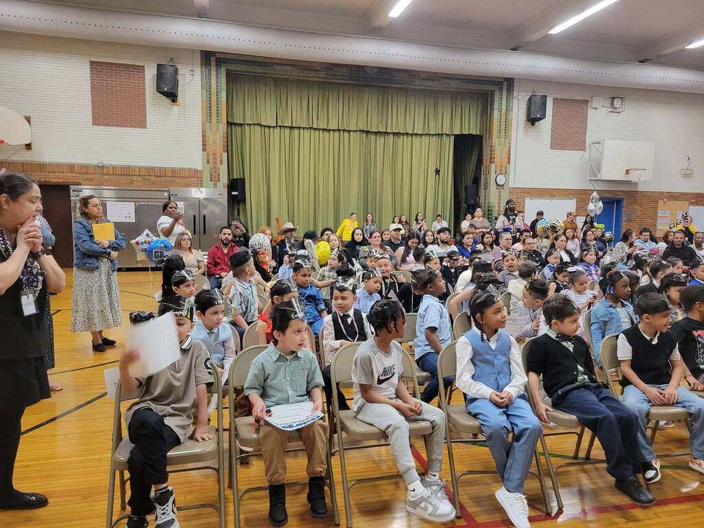 Kindergarten students seated at the school's gym during their promotion ceremony