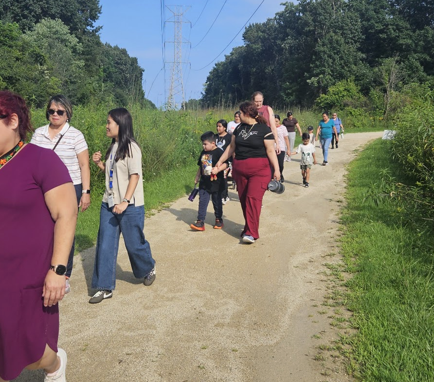 Clark staff, parents, and students walking together in the forest preserve.