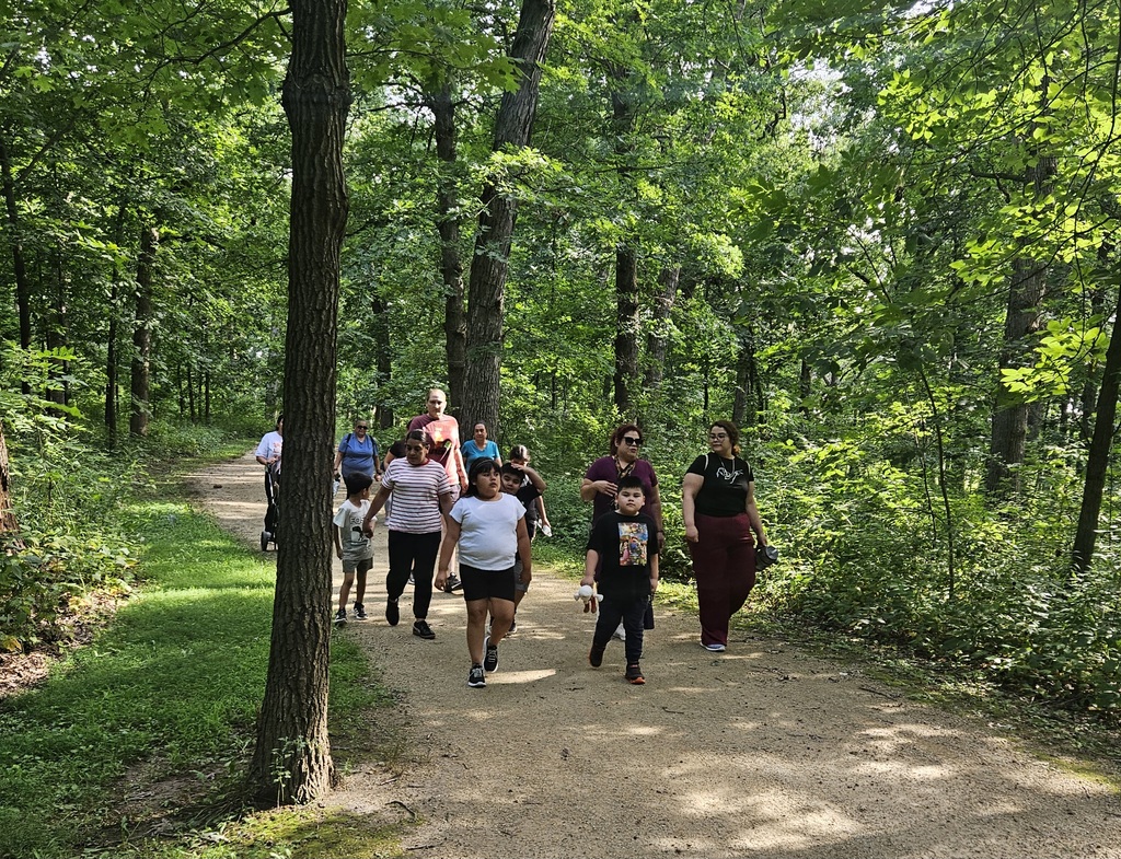 Clark staff, parents, and students walking together in the forest preserve.