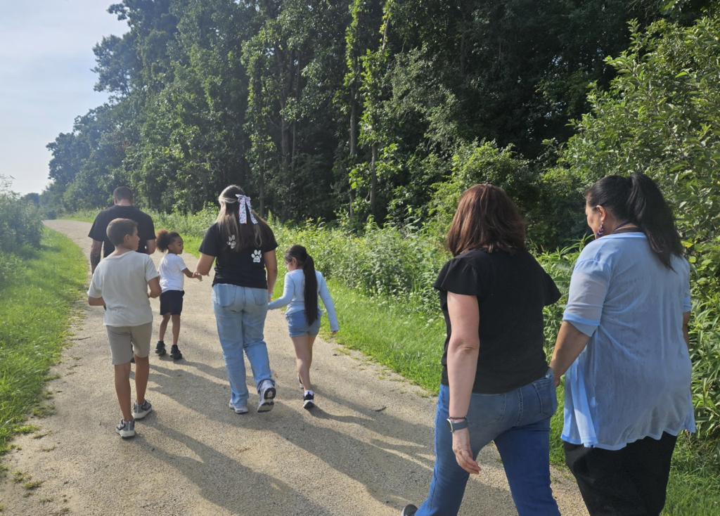 Clark staff, parents, and students walking together in the forest preserve.