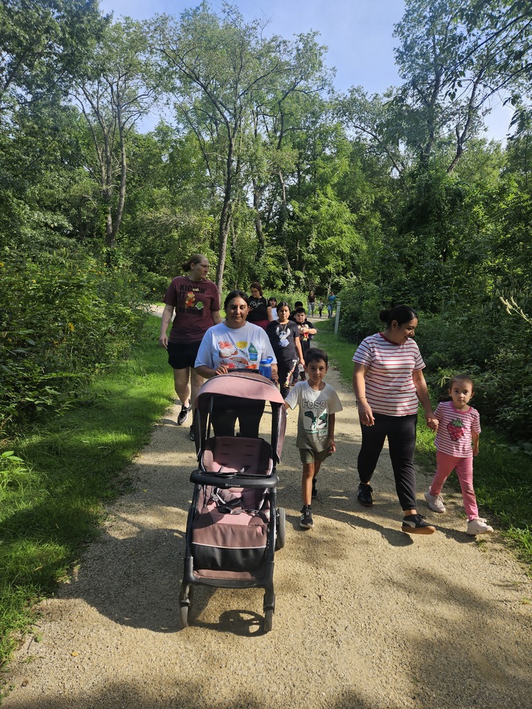 Clark staff, parents, and students walking together in the forest preserve.