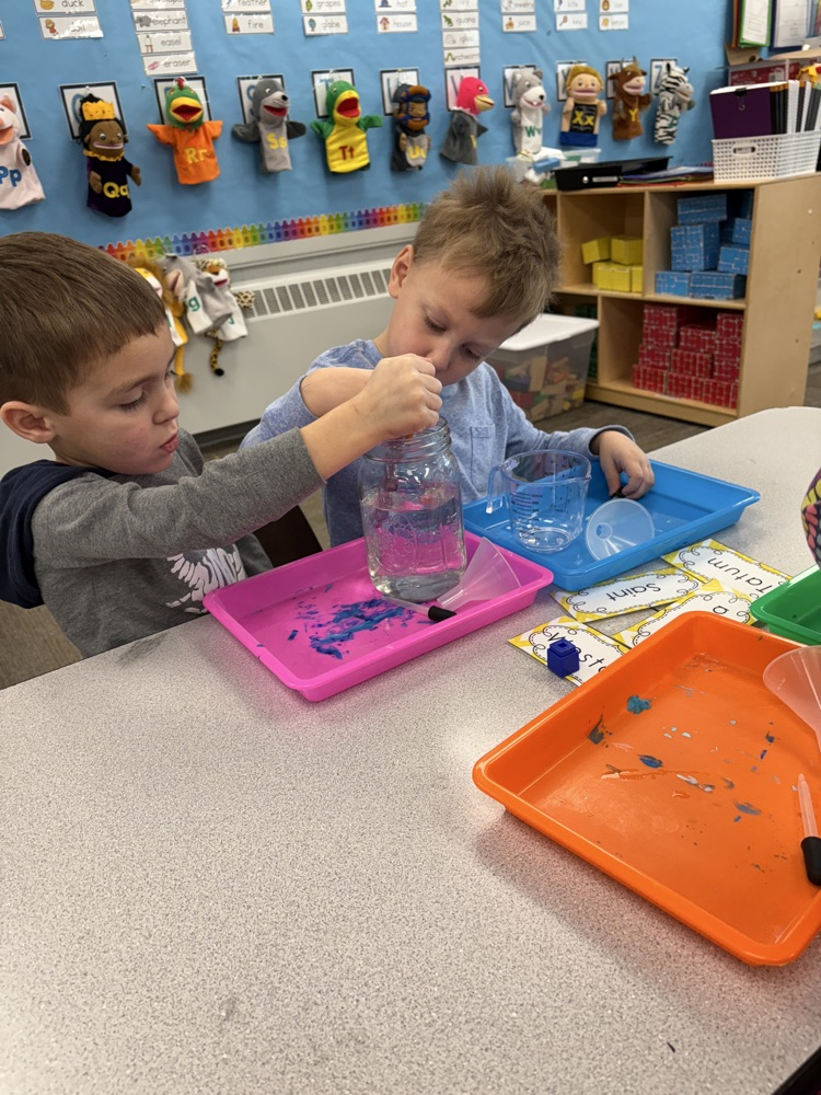 children using eye droppers to transfer water from one container to another