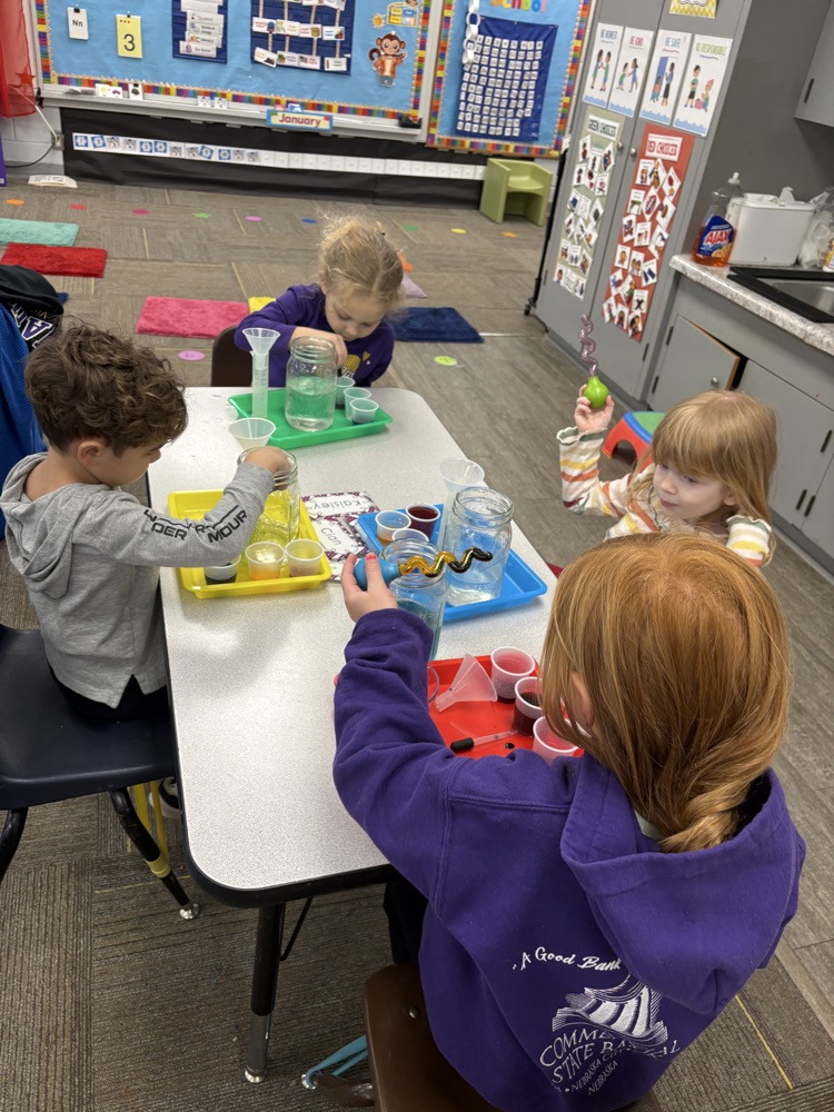 children using eye droppers to transfer water from one container to another
