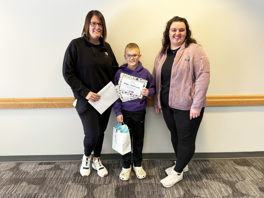 Riggs standing with Mrs. Carlson and Mrs. Compton who awarded him the Stellar Teller award