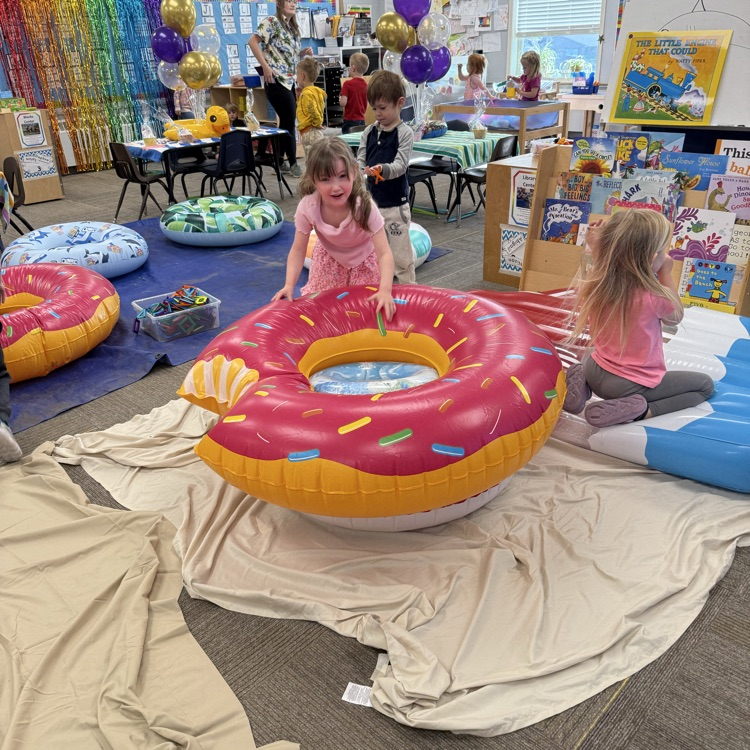 a student is jumping into a giant inflatable donut