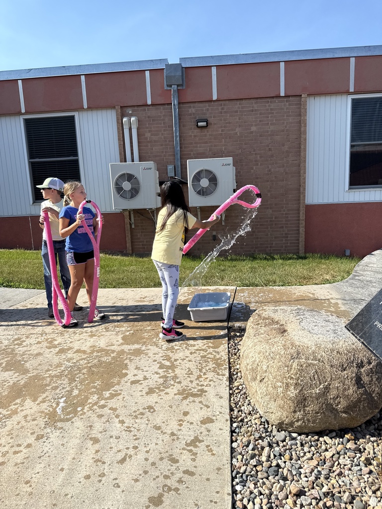 Students use a bubble wand to make giant bubbles.