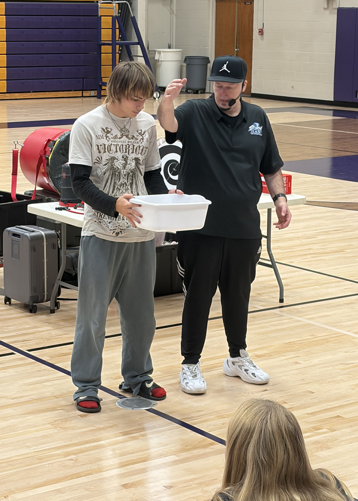 Lane helps Mr. Holla with a downdraft experiment using ping pongs and a leaf blower.