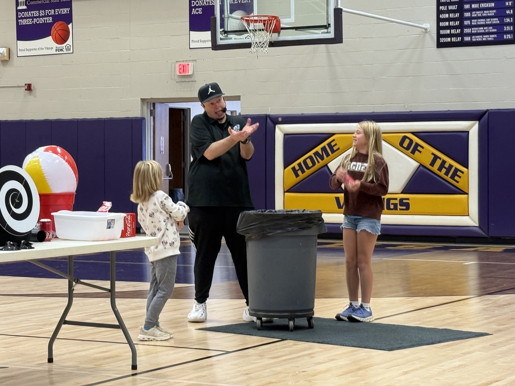 The Cunningham sisters are assisting Rob Holla with a coke can and pop pressure experiment. They are shaking the cans.