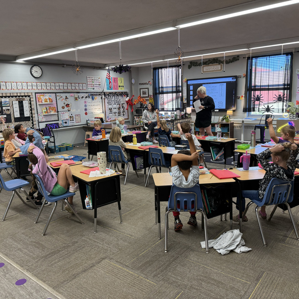 First grade students learning from the first responder in the classroom about fire safety.