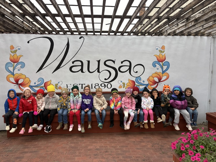 Students gathered together in front of the Wausa painting in the Main Street area
