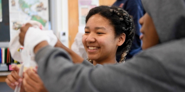 students smiling while working on a project together