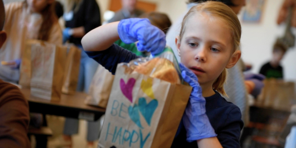 photo of student putting food into a brown paper bag