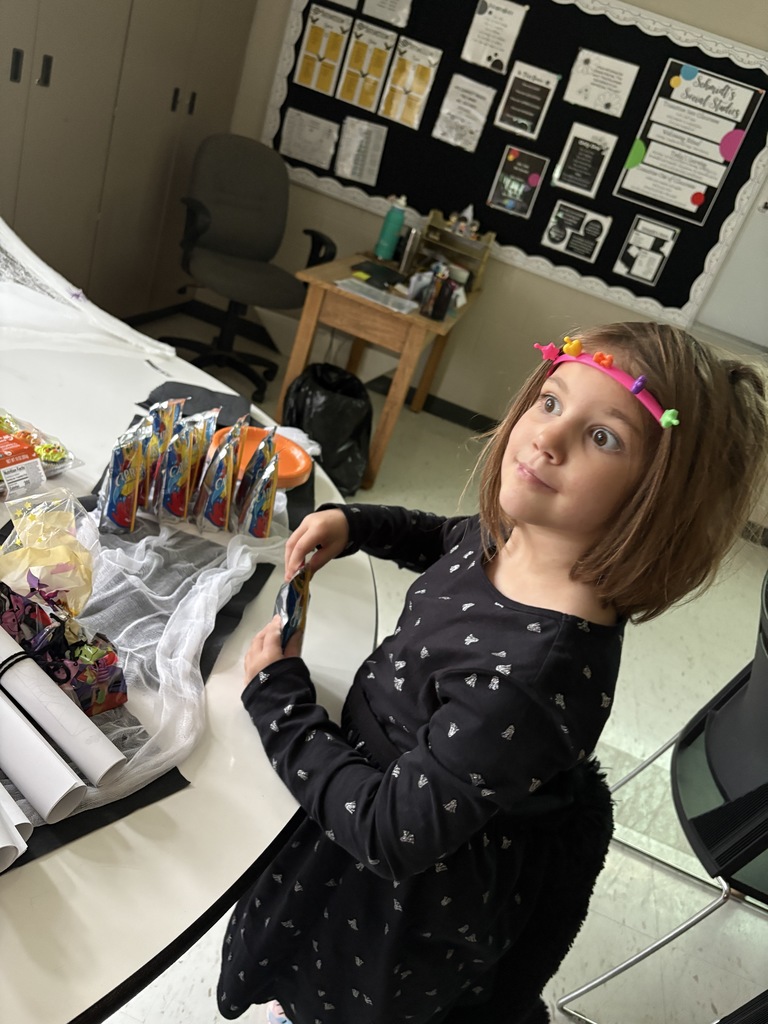 Little student helping set up juice boxes for the party.