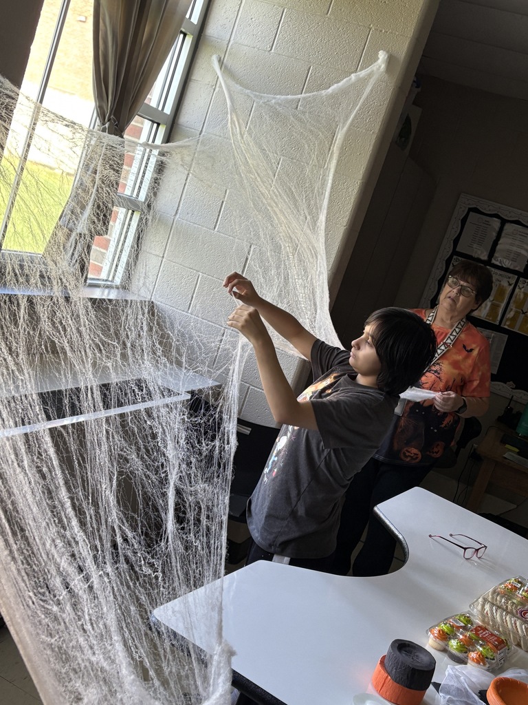Student and para creating a very large spider web. Perfect for holding spider ring party favors.