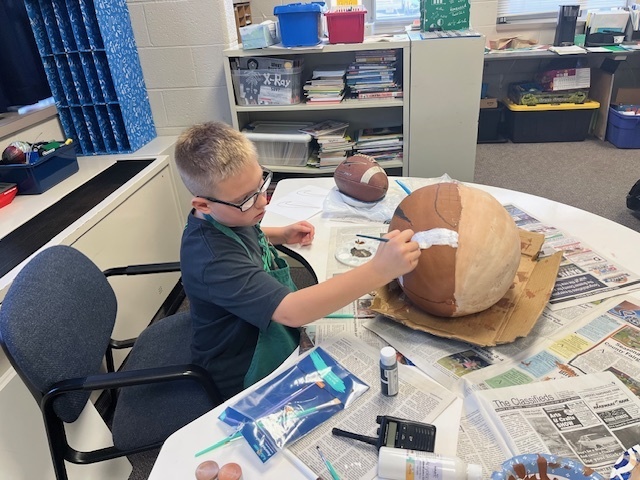 Student painting pumpkin