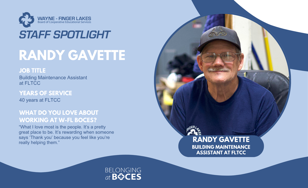 Randy Gavette sits in a rolling chair and smiles at the camera in the Facilities work area