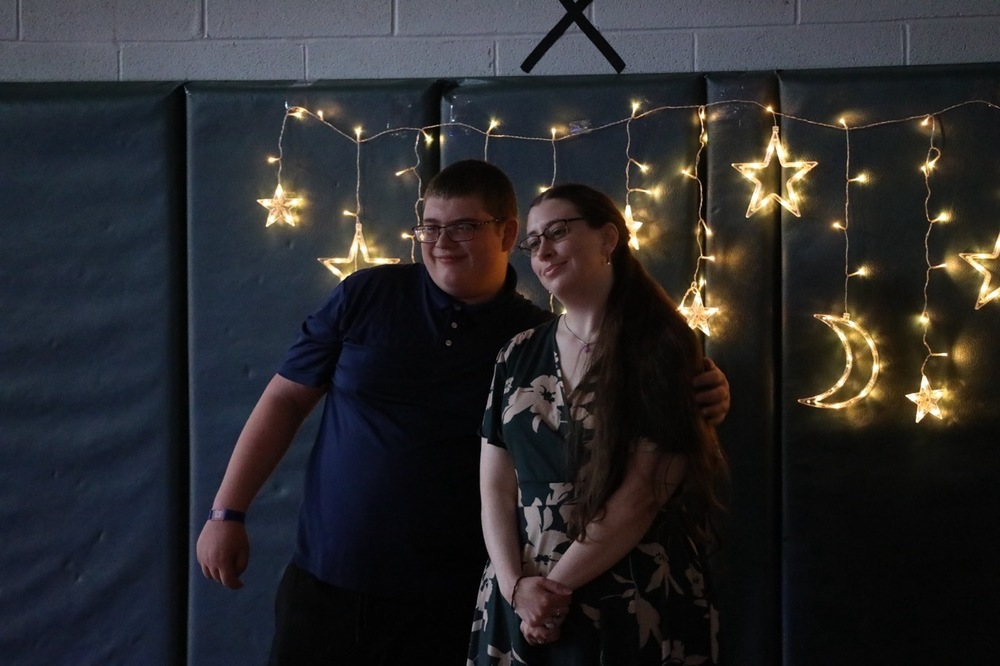 Two FLSS Students pose for a photo in front of a moon and stars banner at Prom