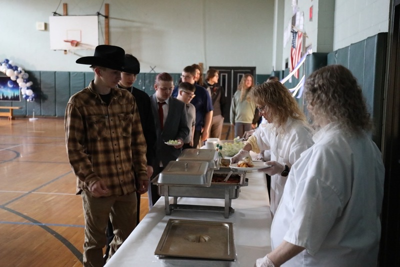 Students wait in line to be served dinner at FLSS Prom