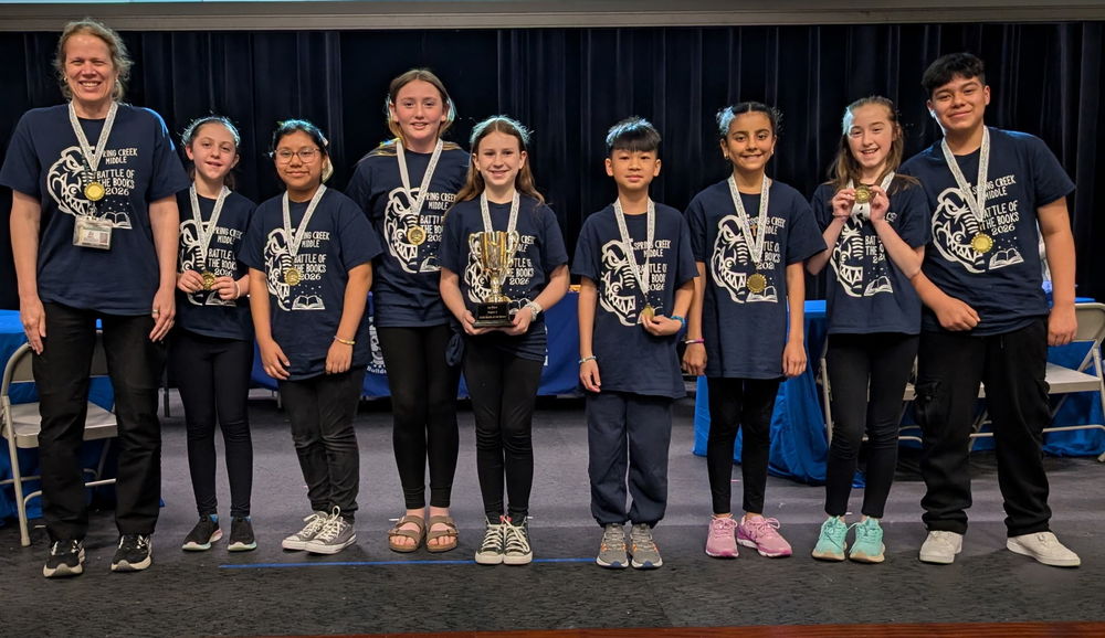 Spring Creek Middle Battle of the Books team standing on stage with medals