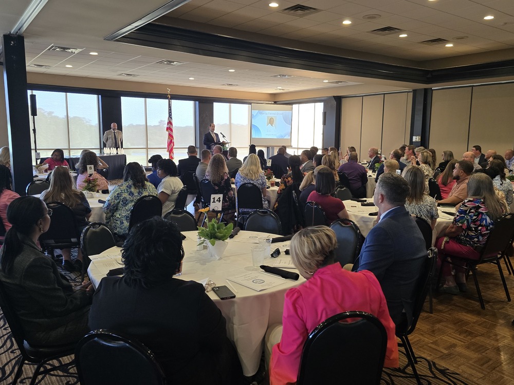 Celebration of excellence program with guests listening to speaker