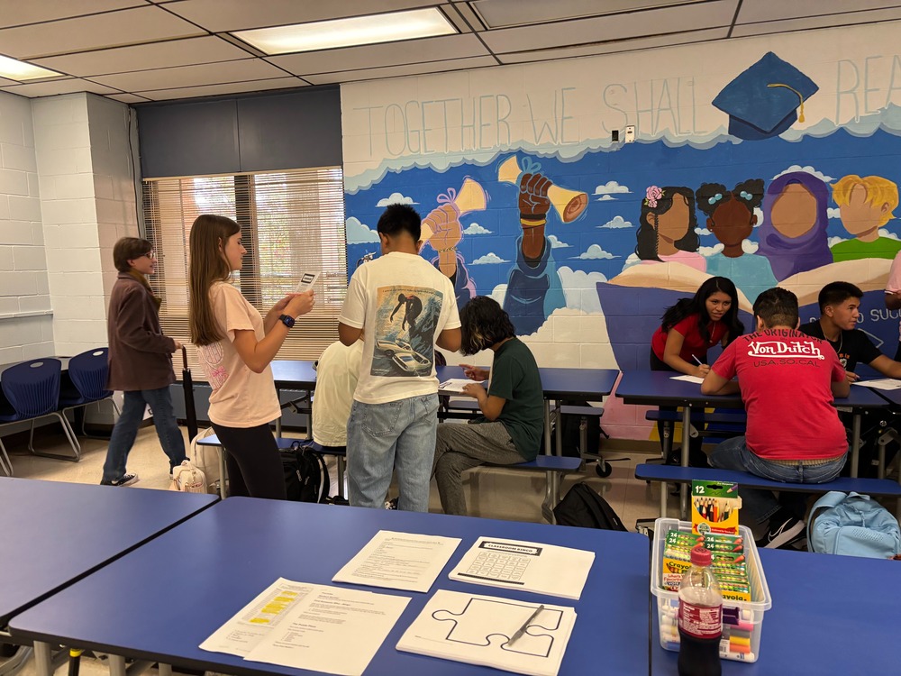 Students in the cafeteria working in groups.