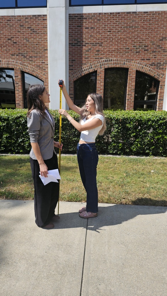 Two students measuring right angles outside