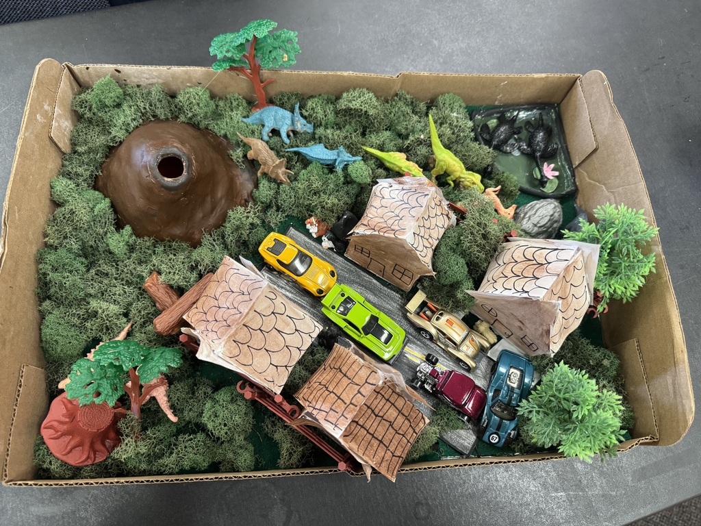 Model of a volcano and a villages with cars.