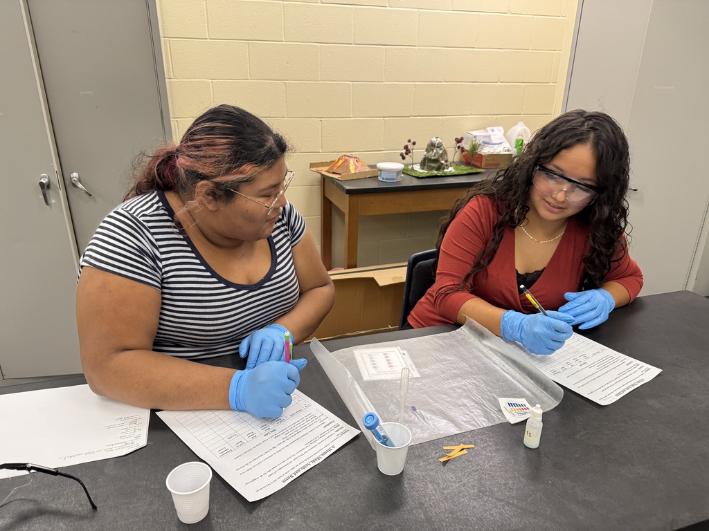 Two young ladies experimenting with acids and bases in class.