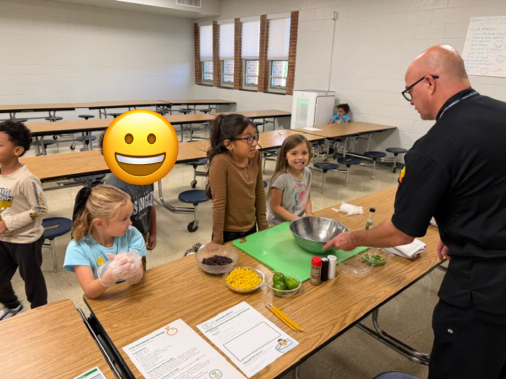Chef Jason holding a bowl in front of a group of students teaching them cooking skills