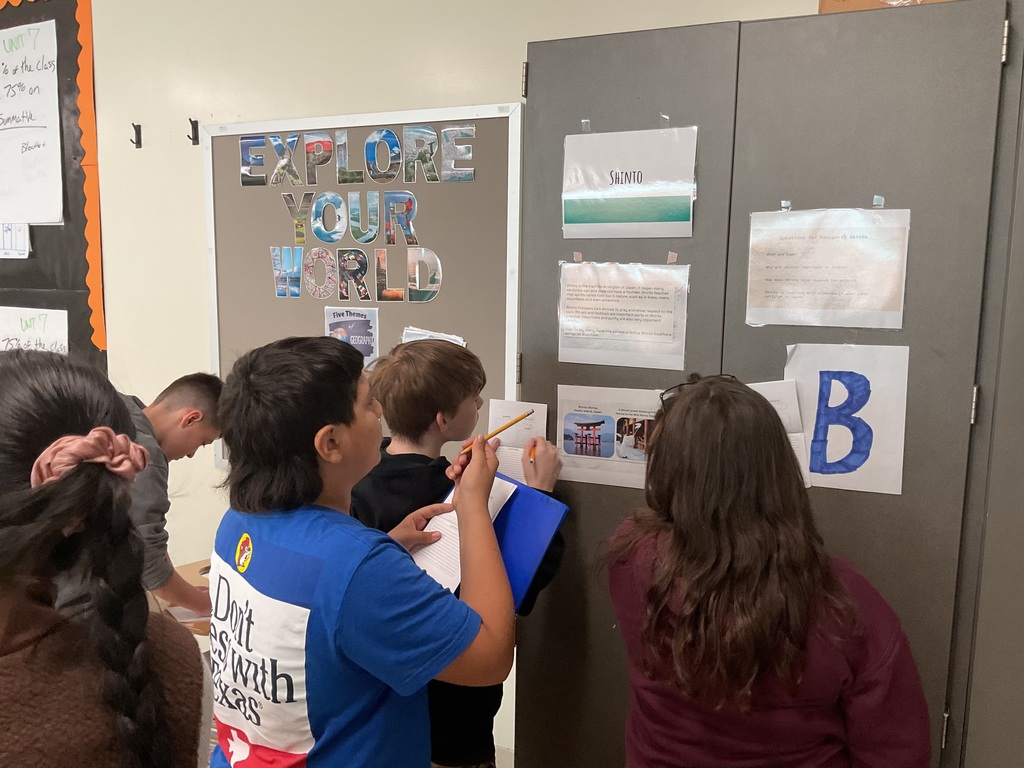 Students looking at Shinto station and writing facts in their passports