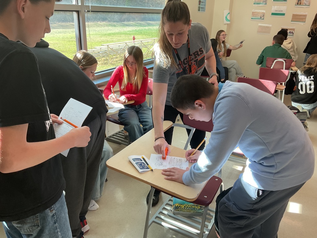 Students getting a stamp in their passport for a stations activity