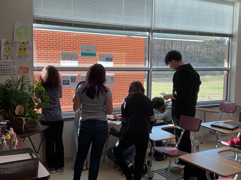 Students looking at Hinduism station and writing facts in their passports