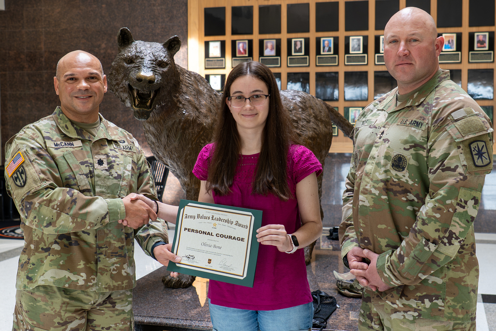 Olivia Bone, a junior at Waynesville High School, received the Fort Leonard Wood Army Values Leadership Award for representing the Army value of personal courage. She is the daughter of Joshua and Stephanie Bone.      Lt. Col. Chris McCann, the battalion commander for the 787th Military Police Battalion, and Master Sgt. Michael Self, the S3 NCOIC, presented the award to Bone on April 15, 2026, at Waynesville High School. 