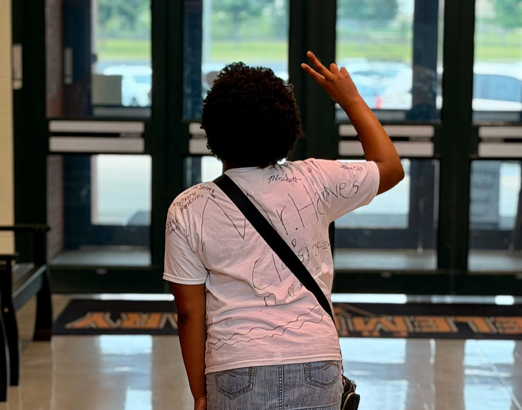 A student waving bye for the school year