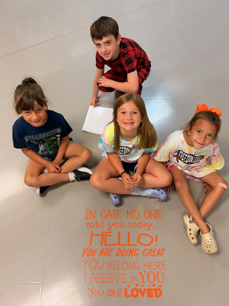 Three students sitting next to a sign that states, " "In case no one told you today, HELLO! You are doing great. You belong here. I believe in you. You are loved."