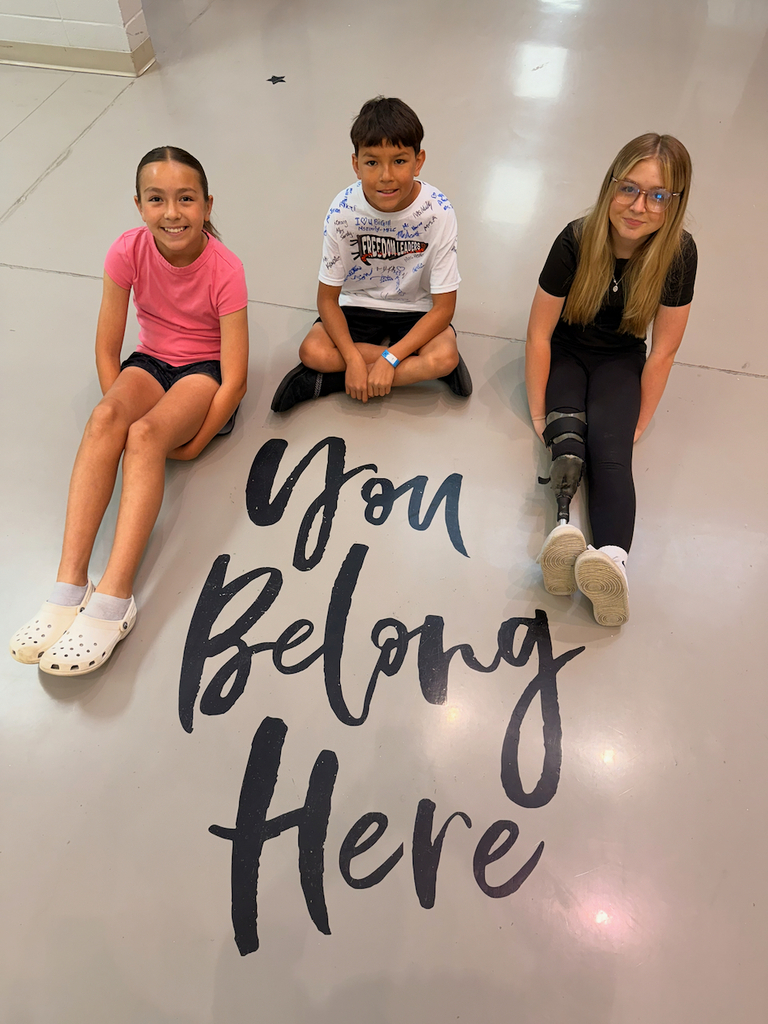 Students sitting next to a message that states, "You belong here." 