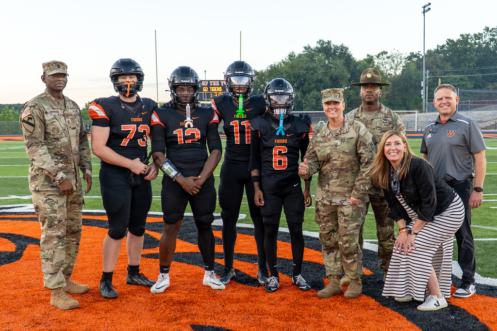 Fort Leonard Wood leaders with Waynesville High School varsity football captains, Superintendent Hilary Bales and WHS Principal Brian Vernon on the field at Tiger Stadium.